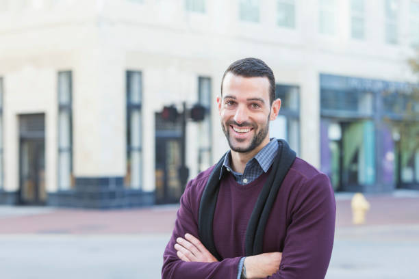 istock Young man with beard standing on city street corner 652836960