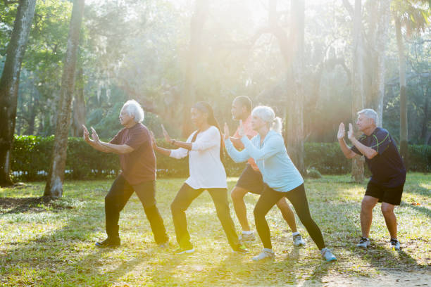 multi-ethnischen gruppe von senioren tai chi-kurs teilnehmen - senior adult multi ethnic group friendship women stock-fotos und bilder