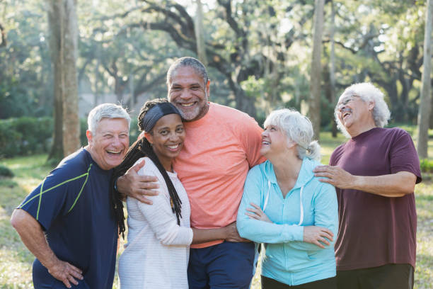 gruppo di cinque anziani multietnici in piedi nel parco - senior adult senior couple exercising african ethnicity foto e immagini stock