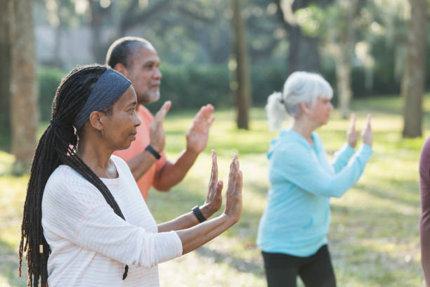 groupe multi-ethnique de personnes âgées prenant des classe de tai chi - tai chi photos et images de collection