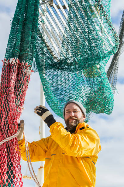 istock Man working on commercial fishing boat, preparing net 652843812