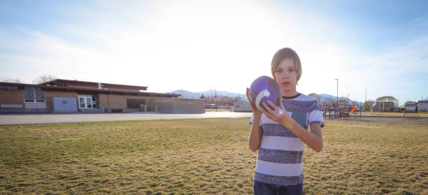 istock Boy with braces playing with football 652858048
