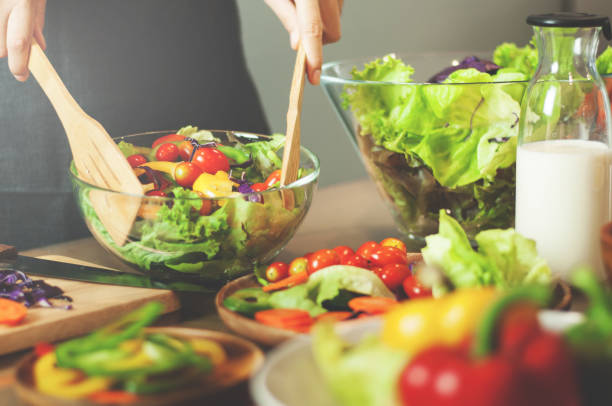 istock Woman cooking salad with vegetables. 652867968