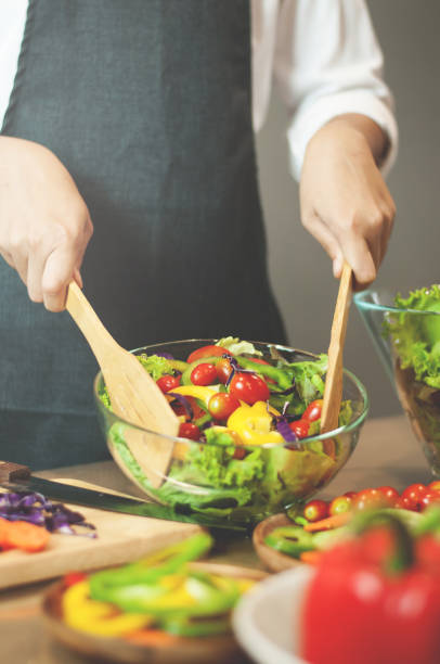 istock Woman cooking salad with vegetables. 652867986