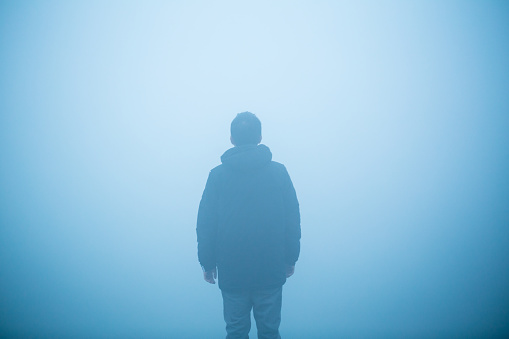 young man standing in the mist