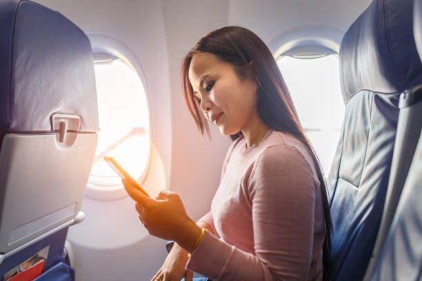 istock Asian woman use of mobile phone inside airplane 652874998