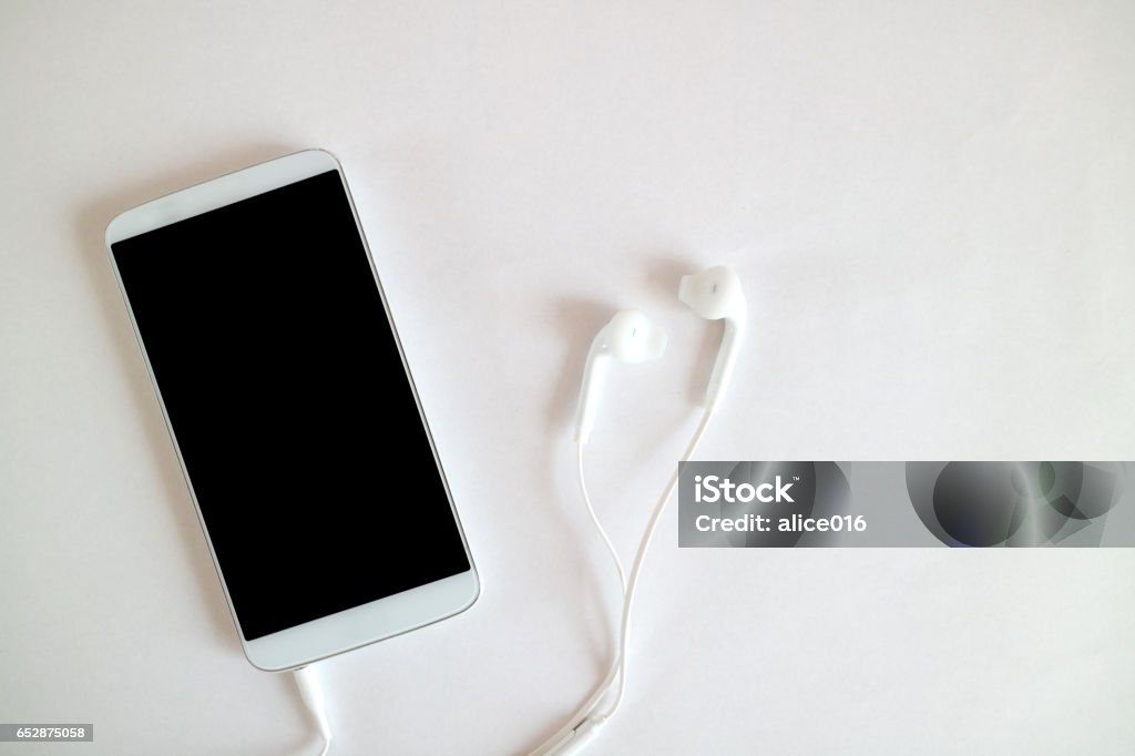 technology, music, gadget and object concept - close up of white smartphone and earphones close up of white smartphone and earphones Podcasting Stock Photo