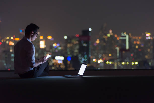 homem de negócios usando o smartphone e laptop no telhado - roof of the world - fotografias e filmes do acervo