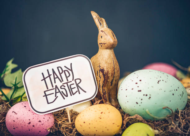Easter still life arrangement with rustic bunny, speckled eggs and holiday message. Sign designed and created by photographer.