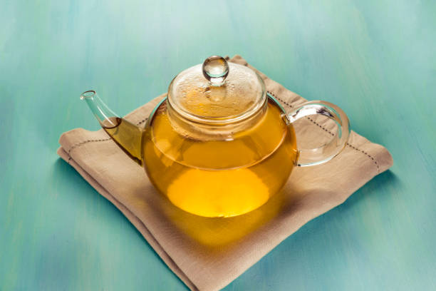 istock Teapot full of tea on teal texture with copyspace 652882542