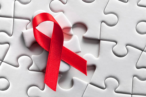solución. cinta roja del conocimiento del sida en rompecabezas. - aids awareness ribbon fotos fotografías e imágenes de stock