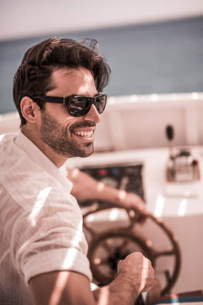 istock Young happy man driving the boat in summer day. 652904038
