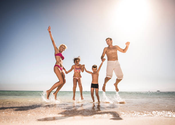istock Playful family having fun while jumping on the beach. 652904826