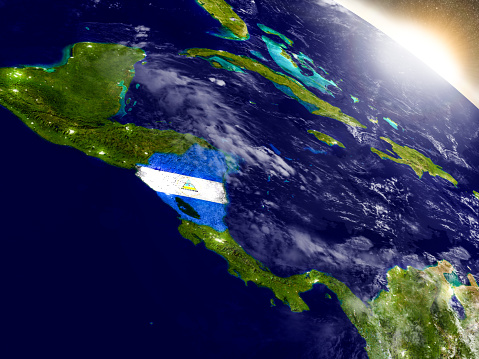 Nicaragua with embedded flag on planet surface during sunrise. 3D illustration with highly detailed realistic planet surface and visible city lights. 3D model of planet created and rendered in Cheetah3D software, 9 Mar 2017. Some layers of planet surface use textures furnished by NASA, Blue Marble collection: http://visibleearth.nasa.gov/view_cat.php?categoryID=1484