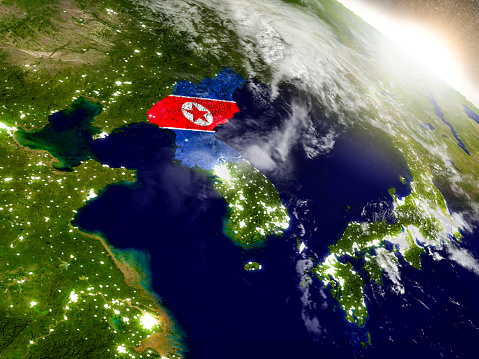 North Korea with embedded flag on planet surface during sunrise. 3D illustration with highly detailed realistic planet surface and visible city lights. 3D model of planet created and rendered in Cheetah3D software, 9 Mar 2017. Some layers of planet surface use textures furnished by NASA, Blue Marble collection: http://visibleearth.nasa.gov/view_cat.php?categoryID=1484