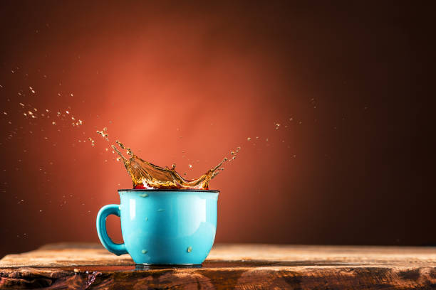 istock Brown splashes out drink from cup of tea on a brown background 652911898
