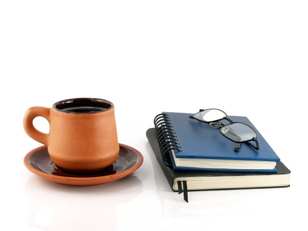 istock baked clay coffee cup with saucer and two diary books with eyeglasses 652914534
