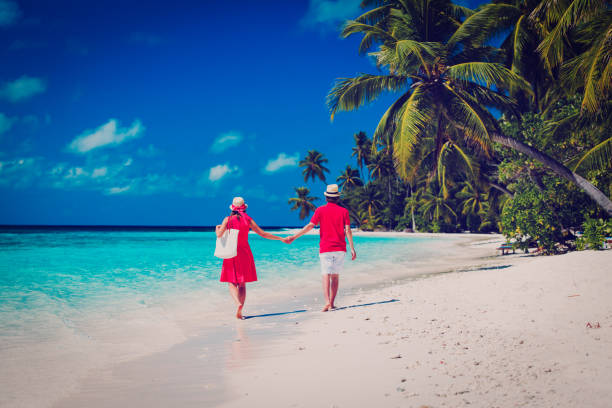 istock happy loving couple walking on beach 652915830
