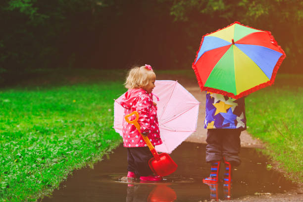 istock little boy and girl with umbrellas playing in spring 652918008