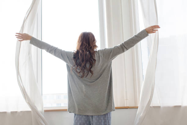 istock Female opens the curtains in the morning 652918200
