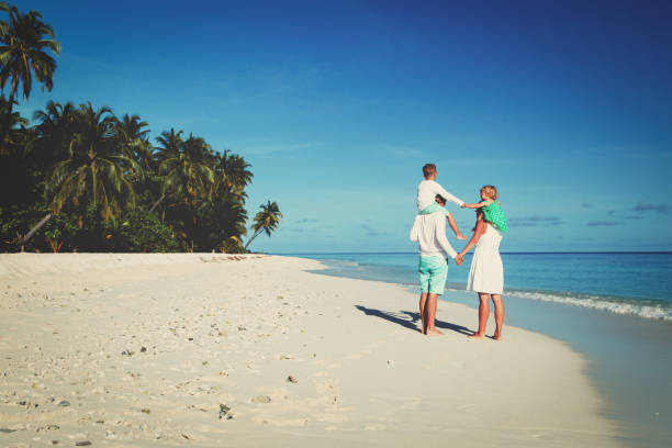 istock happy family with two kids walking on beach 652918470