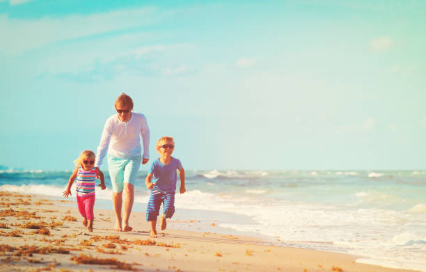 istock father with little son and daughter run at beach 652920754