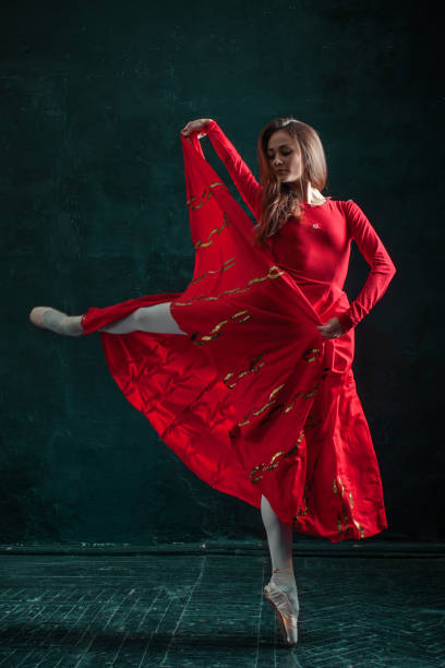 ballerine posant dans des chaussons de pointe au pavillon en bois noir - women dancing contemporary red photos et images de collection