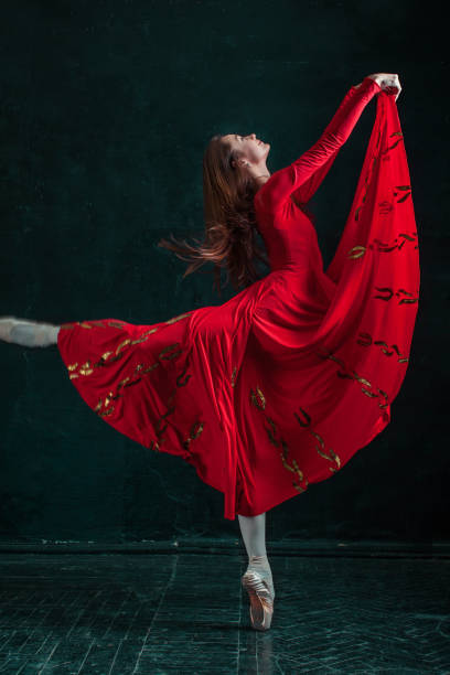 ballerine posant dans des chaussures à pointe au pavillon en bois noir - women dancing contemporary red photos et images de collection