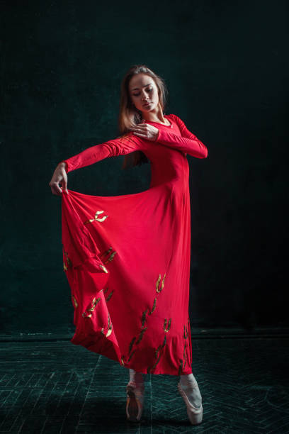 ballerine posant dans des chaussons de pointe au pavillon en bois noir - women dancing contemporary red photos et images de collection