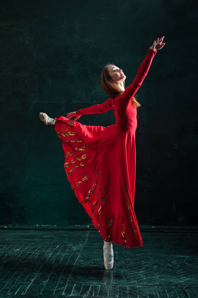 ballerine posant dans des chaussons de pointe au pavillon en bois noir - women dancing contemporary red photos et images de collection