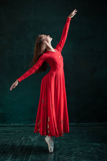 ballerine posant dans des chaussons de pointe au pavillon en bois noir - women dancing contemporary red photos et images de collection