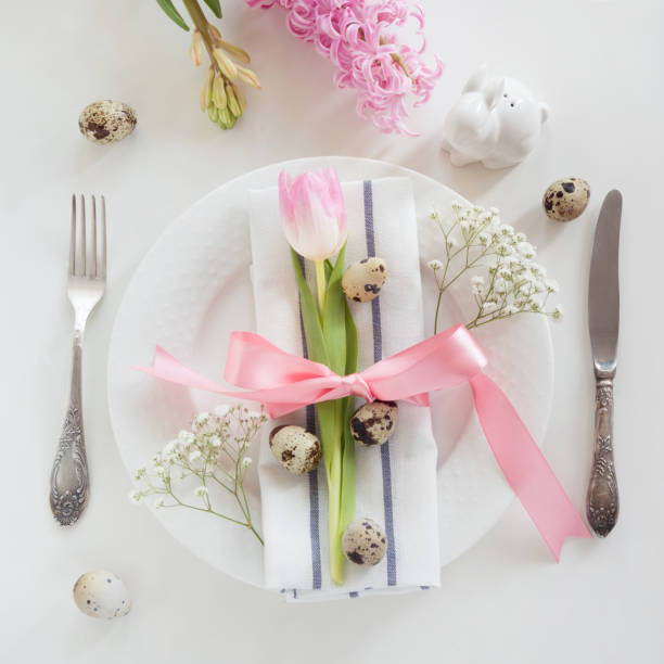 istock Elegance table setting with pink ribbon and tulip on white background. Spring romantic dinner. Top view. 652924988