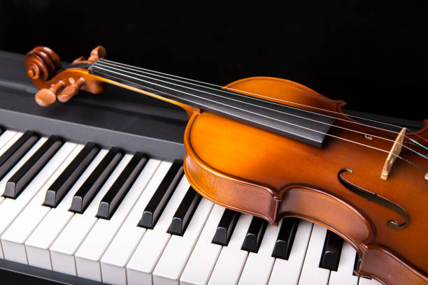 istock Violin on the piano on a black background 652928964