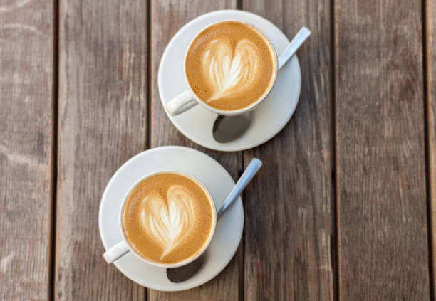 istock A cup of coffee with heart pattern in a white cup on wooden background 652929282