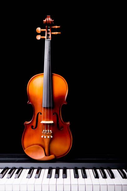 istock Violin on the piano on a black background 652929382