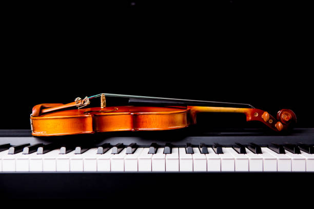 istock Violin on the piano on a black background 652931614