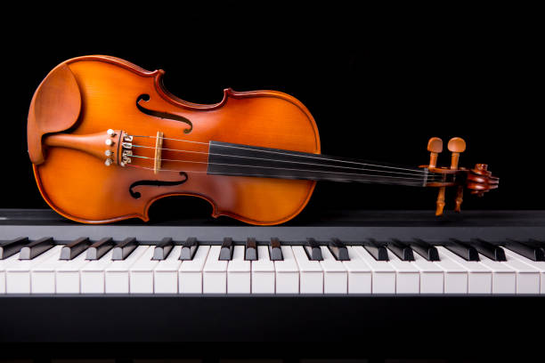 istock Violin on the piano on a black background 652932056