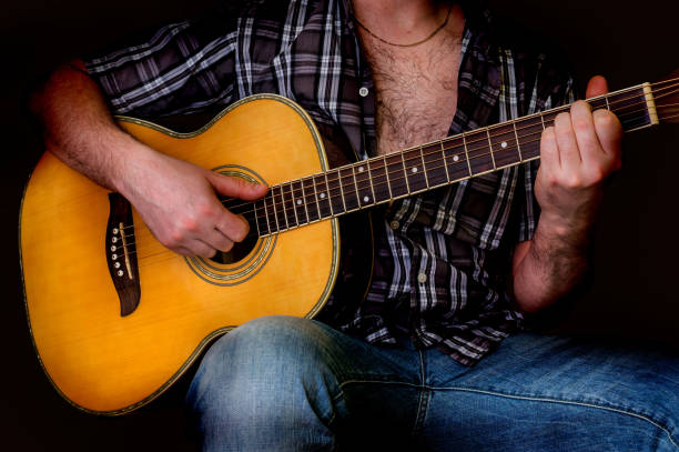 istock Young man playing acoustic guitar - isolated on black 652936242