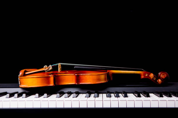 istock Violin on the piano on a black background 652938730