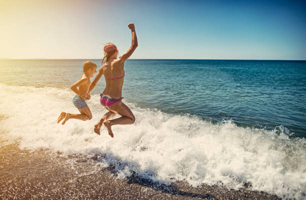 Kids jumping into sea