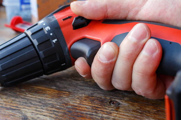 istock Screwdriver in hand against the wooden table closeup 652943202