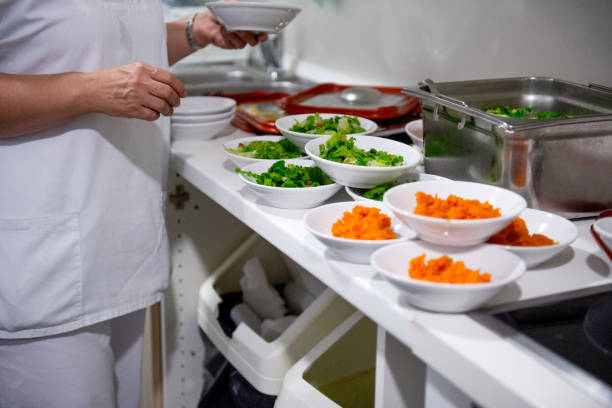 assistant preparing food portions for the seniors in the nursery home - 96 well imagens e fotografias de stock