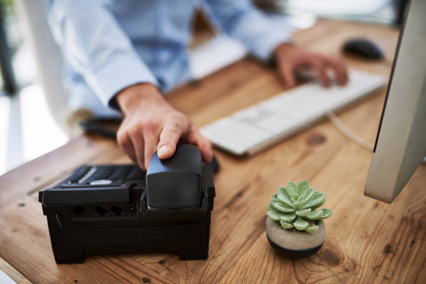 When success calls, pick up that phone Cropped shot of a man holding the receiver of a telephone at work answering stock pictures, royalty-free photos & images