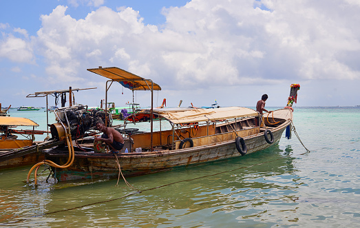 Shot of two Thai man preparing their boat before heading out to sea