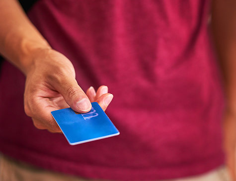 Cropped closeup shot of a man handing over a credit card