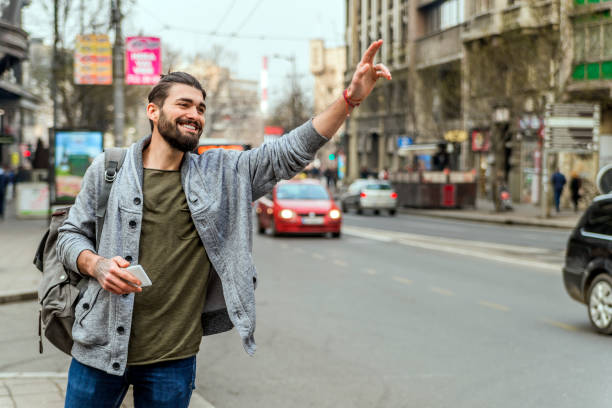 istock Young White Man Holding A Cellphone Hailing Uber Taxi 652994692
