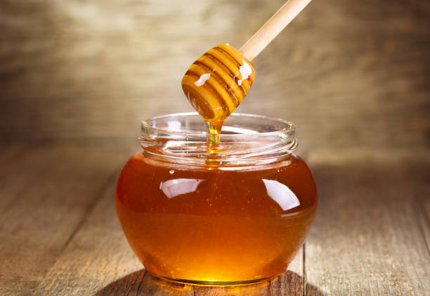 istock pouring honey into a glass jar 653000692