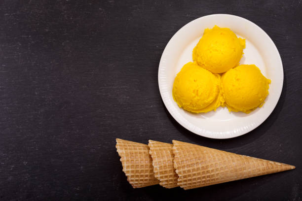 istock plate of mango ice cream scoops and waffle cones 653000712