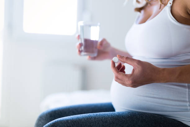 istock Pregnant woman taking medication pill 653003446