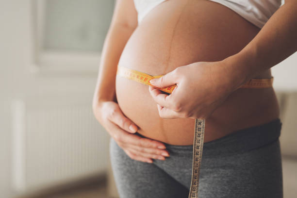 istock Pregnant woman measuring belly growth 653003876